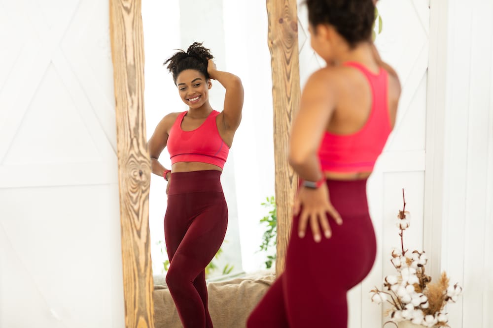 Woman posing in mirror after weight loss