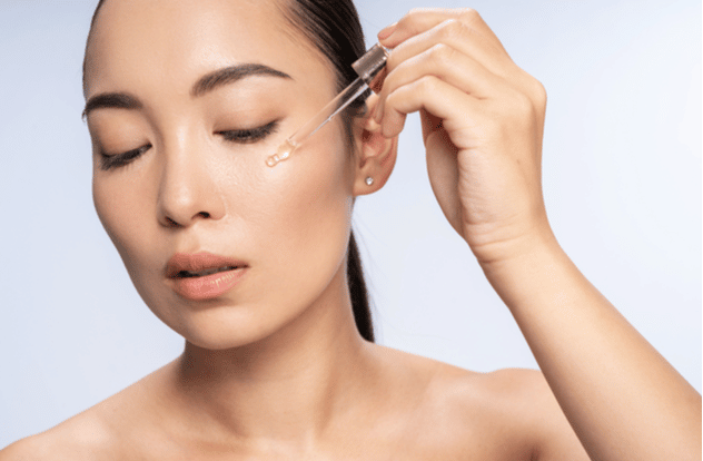 Woman applying vitamin C serum