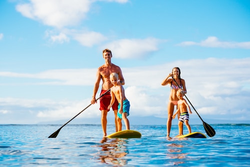 Family Having Fun Stand Up Paddling Together in the Ocean
