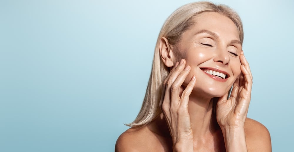 Mature woman smiling happily with beautiful, full skin after Radiesse treatment