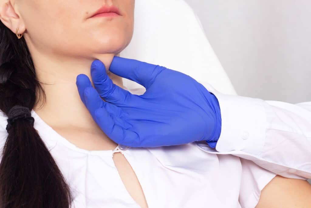gloved hand pinching woman's double chin fat between fingers