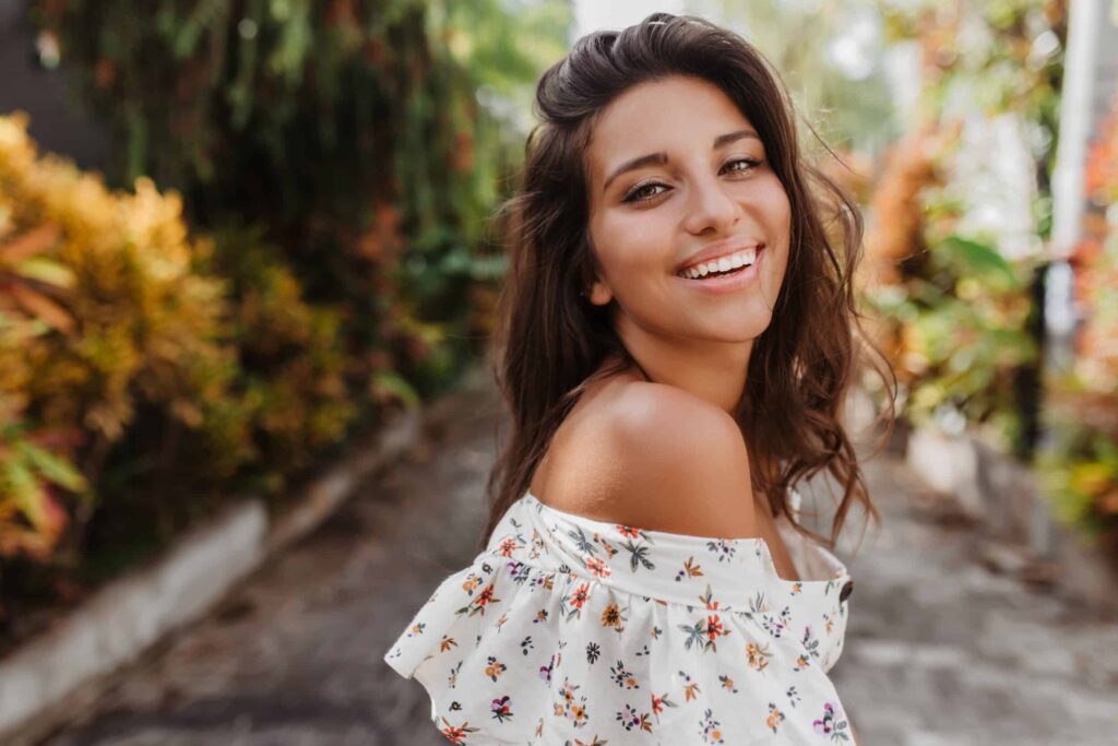 Beautiful young woman outside in the spring or summer with glowing skin