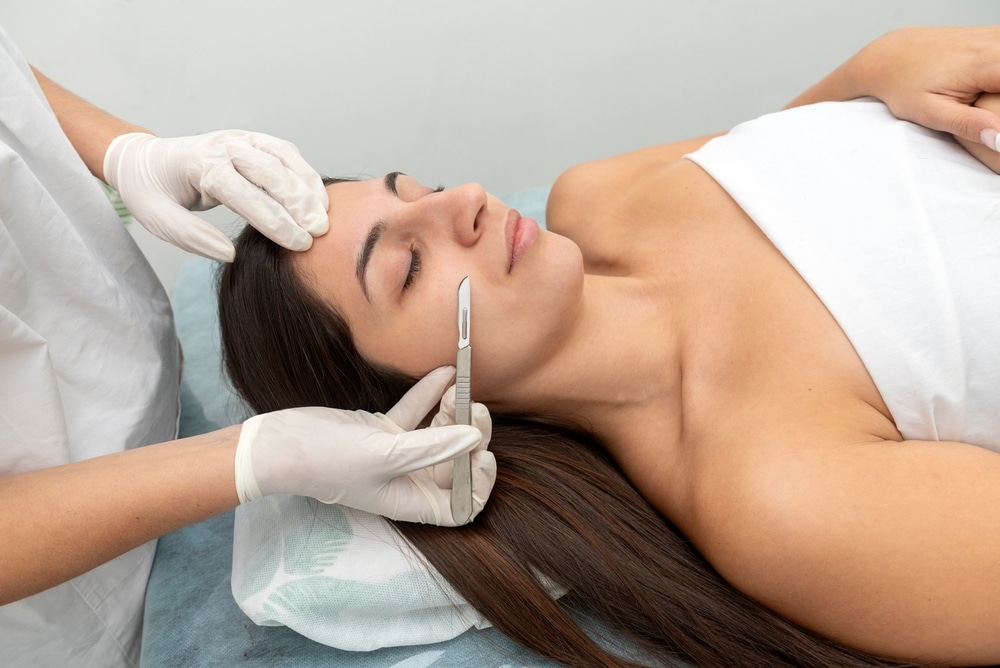 Woman receiving dermaplaning treatment from aesthetician
