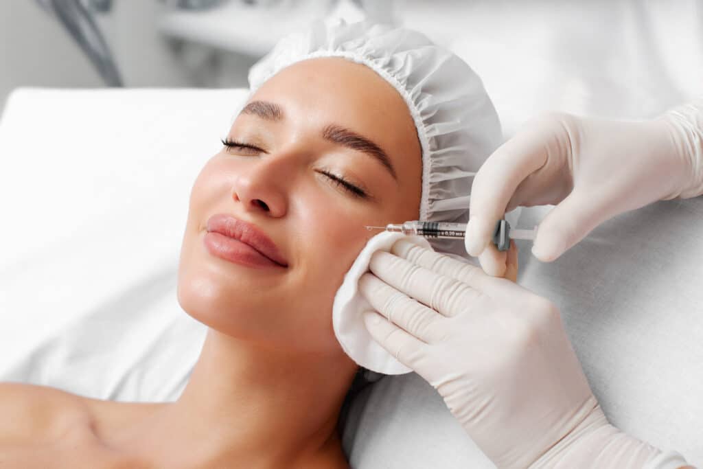 Woman receiving a facial injectable treatment, illustrating an aesthetic appointment where Pro-Nox may help ease treatment anxiety and improve comfort.